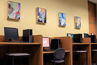 computer workstations with four pieces of art above the stations