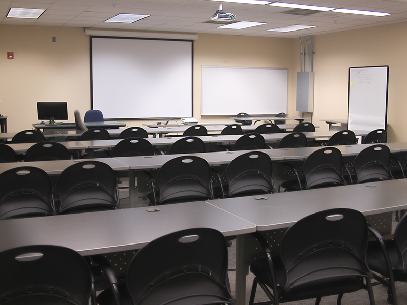 classroom with computers, chairs, and presentation screen