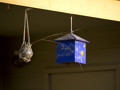 blue birdhouse next to hanging flower pot
